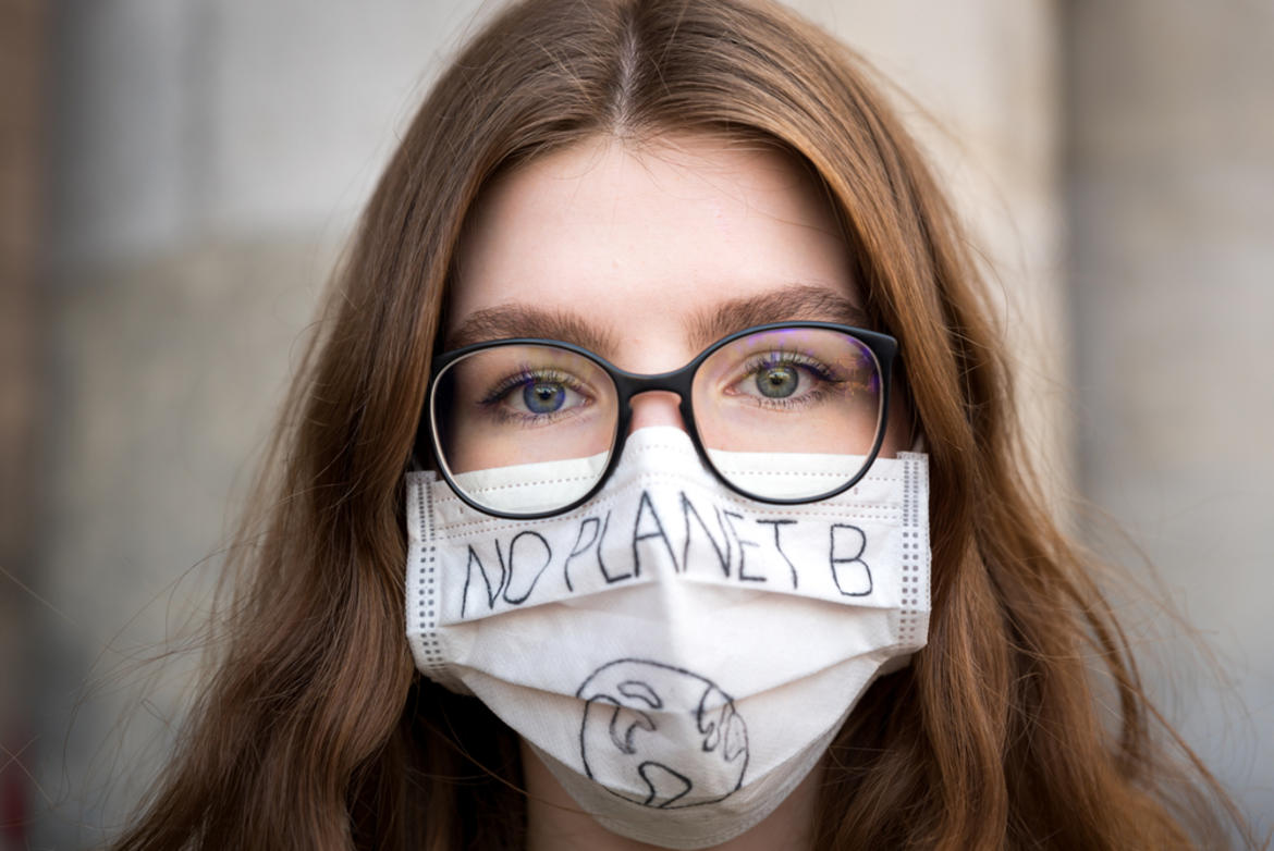 A girl wearing a protective mask with a "no planet B" slogan on it 