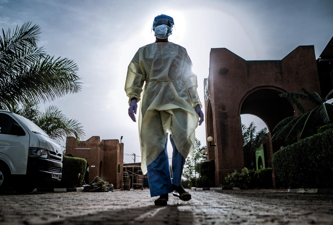 Nurse walking by a hospital building