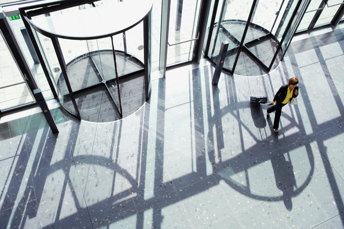 businesswoman walking through revolving door