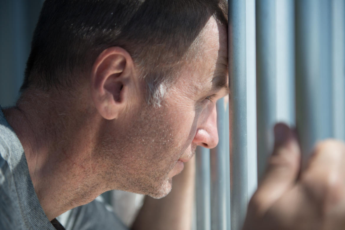 inmate holding prison bars